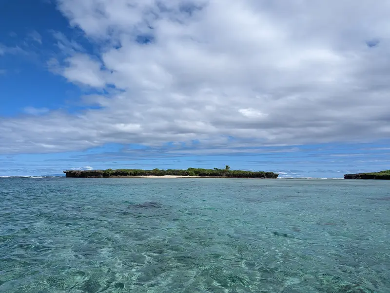 Turquoise lagoon with a small island on the horizon